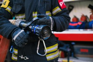 Photo of a firefighter wielding a fire hose.